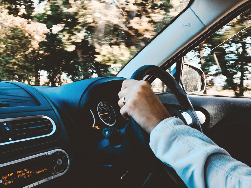 A driver’s hand on the steering wheel during a driving lesson